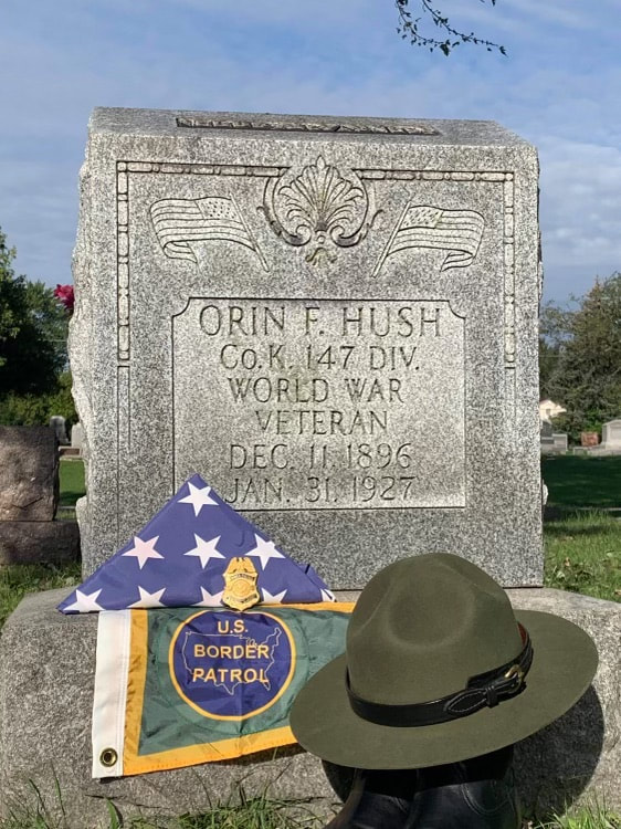 Orin Hush's tombstone adorned with memorabilia from the U.S. Border Patrol.