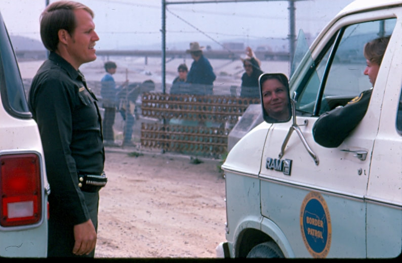 USBP Border Patrol photographs 1970-1990 two agents speaking, one agent is in a sea foam green van