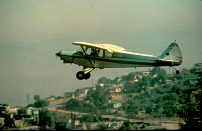 USBP Border Patrol photographs 1970-1990 airplane flying over a town