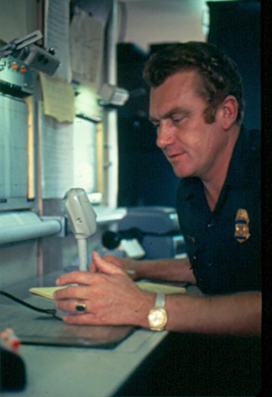 USBP Border Patrol photographs 1970-1990 an agent speaking into a desktop microphone