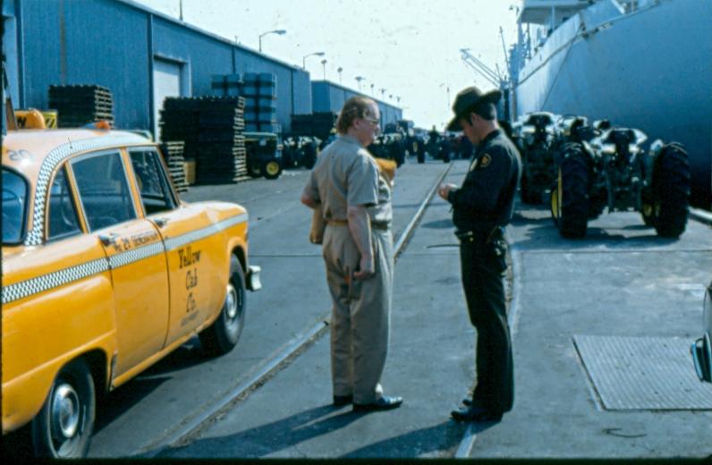USBP Border Patrol photographs 1970-1990 agent wearing a dress uniform speaking to a taxi driver