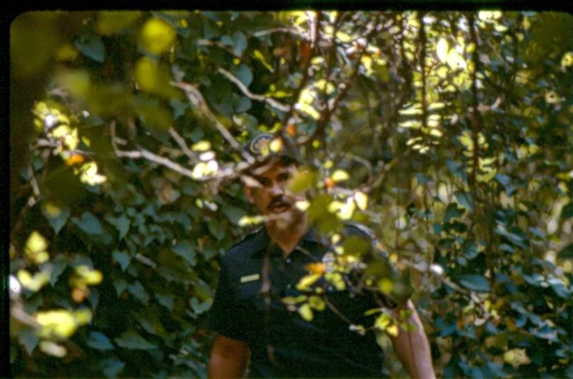 USBP Border Patrol photographs 1970-1990 agent walking through a wooded area