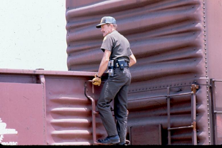USBP Border Patrol photographs 1970-1990 agent stand on the side of a train