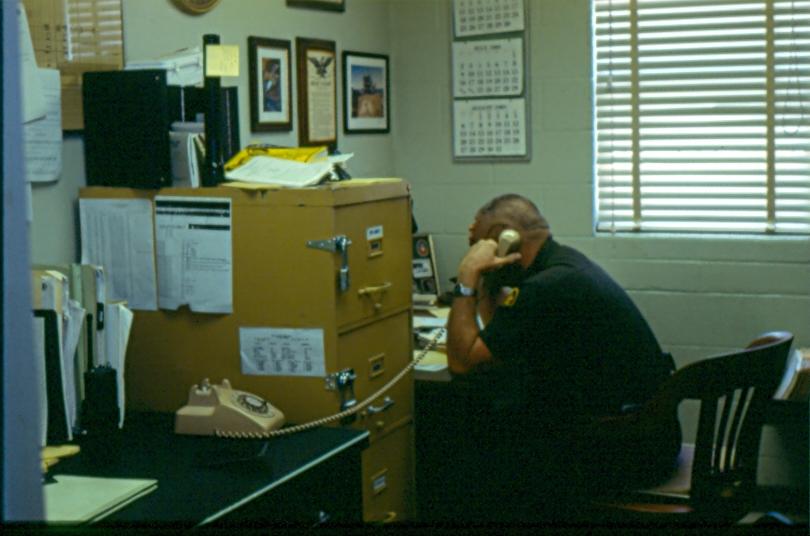 USBP Border Patrol photographs 1970-1990 agent taking on a phone in a station office
