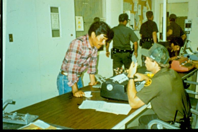 USBP Border Patrol photographs 1970-1990 agents processing a alien at a station