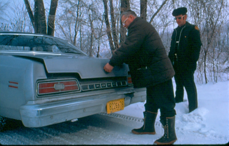 USBP Border Patrol photographs 1970-1990 man opening the car's trunk for an agent in the winter