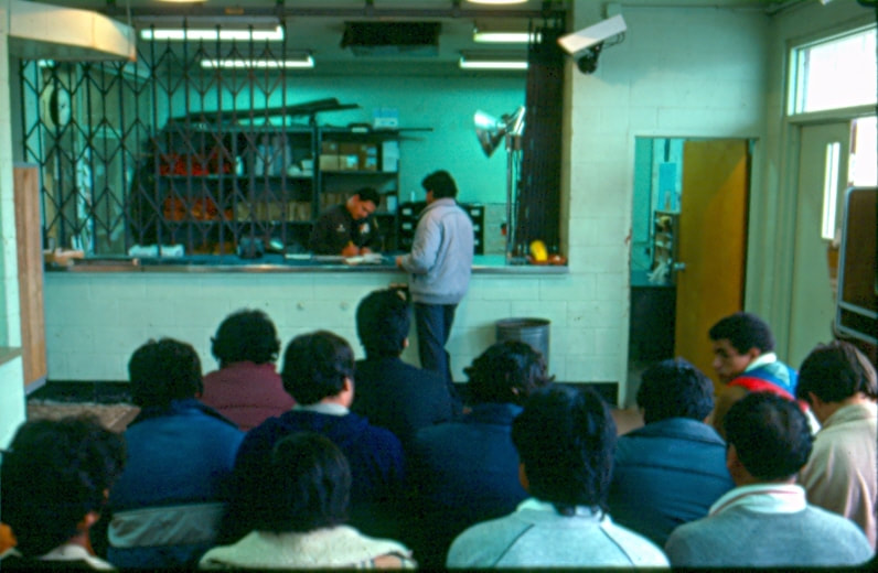 USBP Border Patrol photographs 1970-1990 agent processing arrested aliens at a station