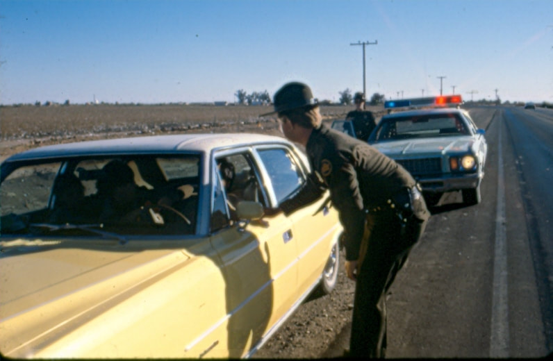 USBP Border Patrol photographs 1970-1990 and agent taking to the driver at an immigration stop