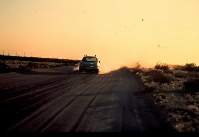 USBP Border Patrol photographs 1970-1990 sea foam green SUV driving on a dirt road