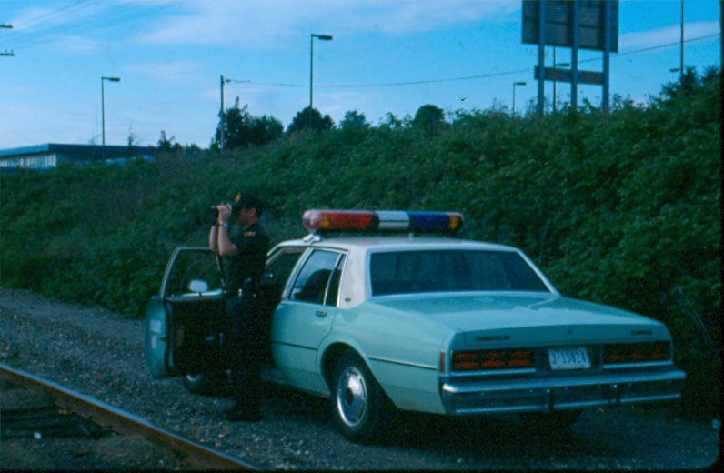 USBP Border Patrol photographs 1970-1990 agent using binoculars sea foam green car