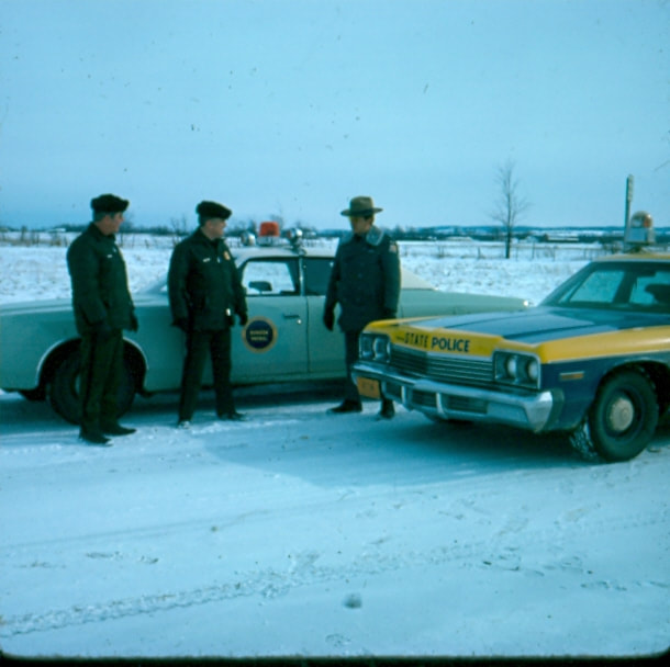 USBP Border Patrol photographs 1970-1990  agents and state police talking outside their cars in the winter