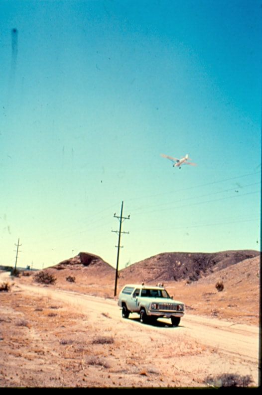 USBP Border Patrol photographs 1970-1990  airplane fin over a sea foam green SUV