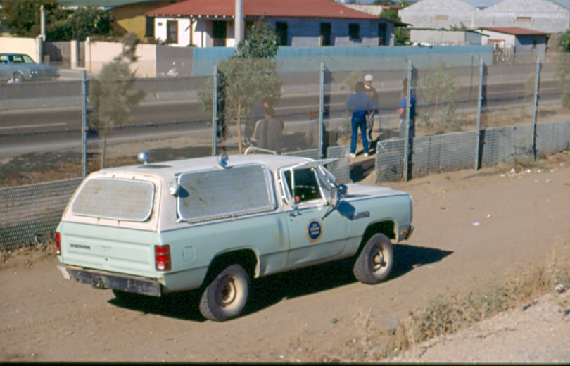 USBP Border Patrol photographs 1970-1990  sea foam green war wagon near the international border fence