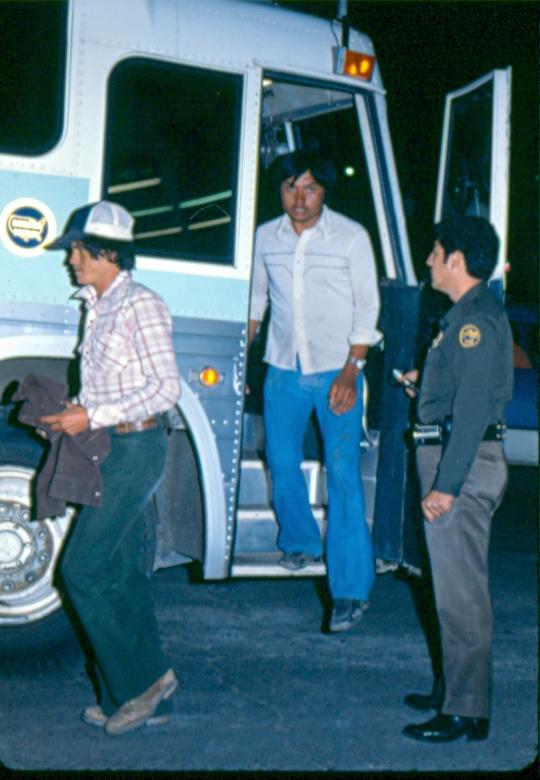USBP Border Patrol photographs 1970-1990  agent helping aliens out of transport bus