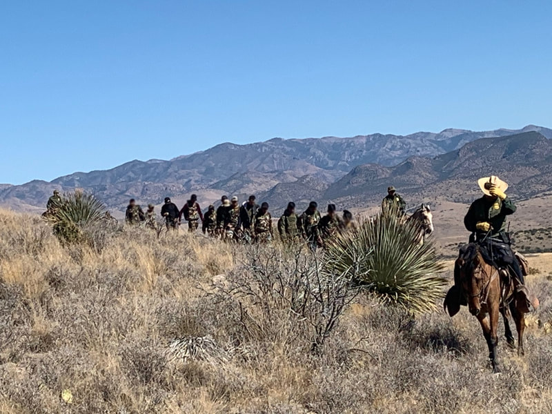 Border Patrol USBP miscellaneous modern horse patrol with a large group of aliens under arrest leading them out of the desert